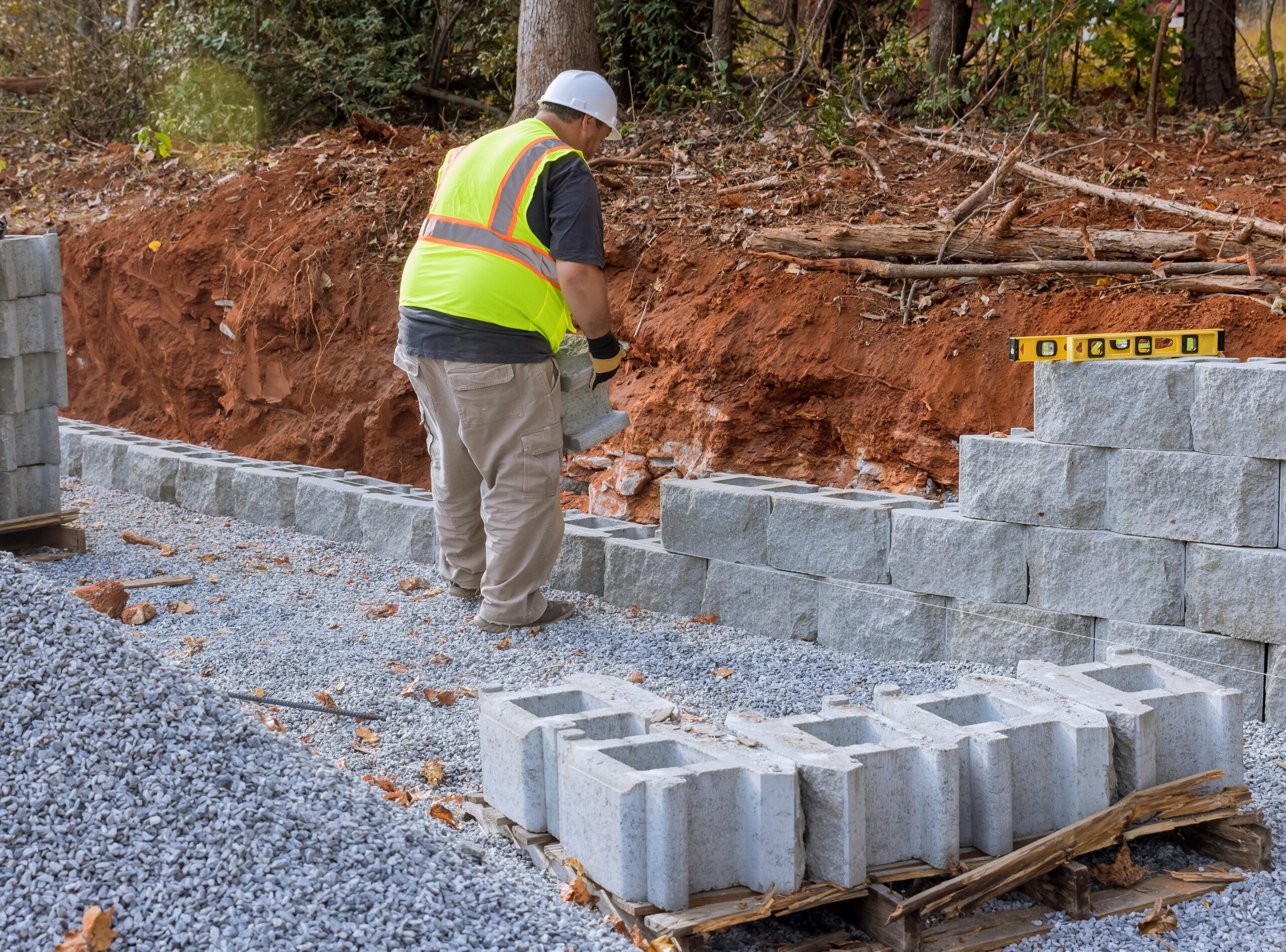Construction worker was installing concrete blocks at construction site near new home as built part of retaining wall